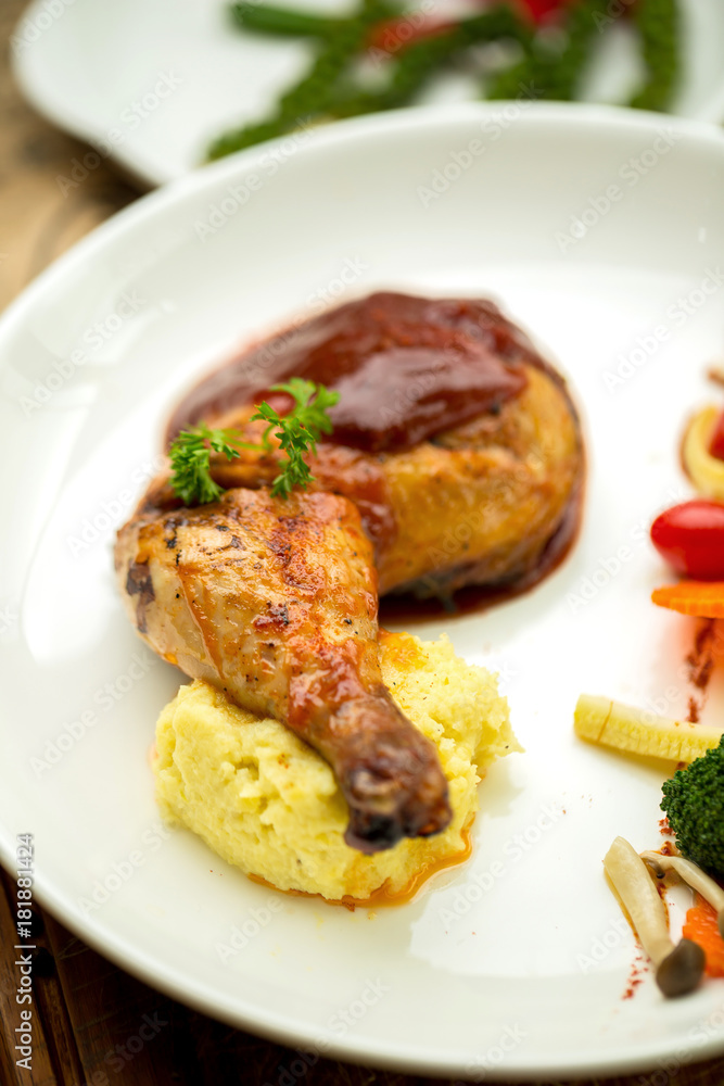Grilled chicken legs and vegetables in white dish isolated on white plate Grilled chicken legs and vegetables in white dish isolated on white plate