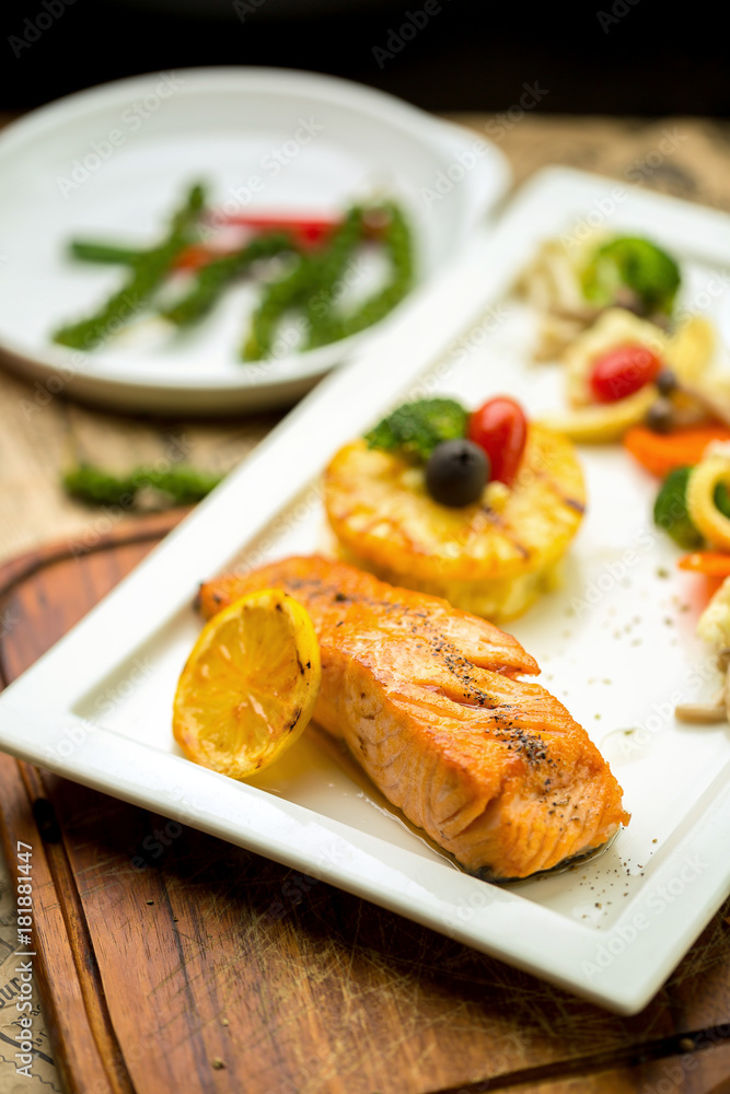 Grilled Salmon with garlic and herb ,lemon isolated on white plate Grilled Salmon with garlic and herb ,lemon isolated on white plate