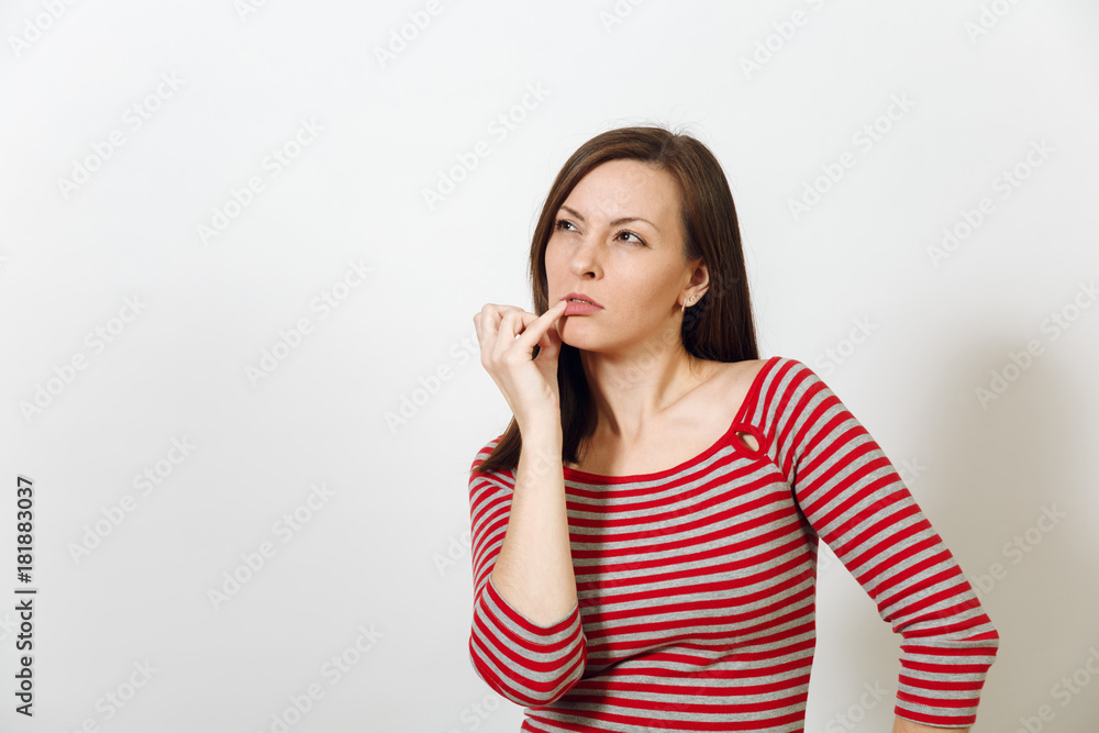 Pretty European young worried and pensive brown-haired woman with healthy clean skin, dressed in casual red and grey clothes lost in thought and conjectures, on a white background. Emotions concept. Pretty European young worried and pensive brown-haired woman with healthy clean skin, dressed in casual red and grey clothes lost in thought and conjectures, on a white background. Emotions concept.
