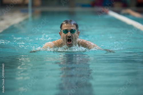 Senior man swimming in frog style - Concept of sport and fun in swimming pool