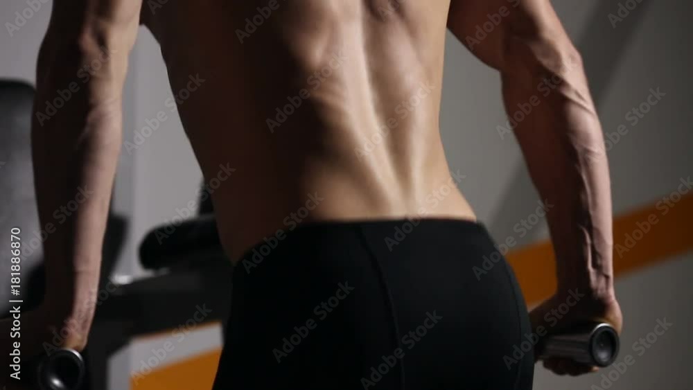 Strong powerful male exercises for pectoral muscles and triceps with dips. Close-up, relief of the body. Strong powerful male exercises for pectoral muscles and triceps with dips. Close-up, relief of the body.
