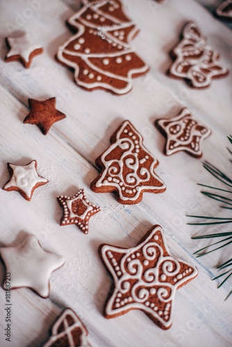 A variety of Christmas gingerbread cookies are laid out on a whi