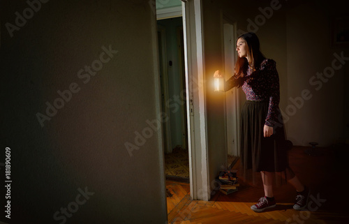 Young girl in black vintage dress with lantern
