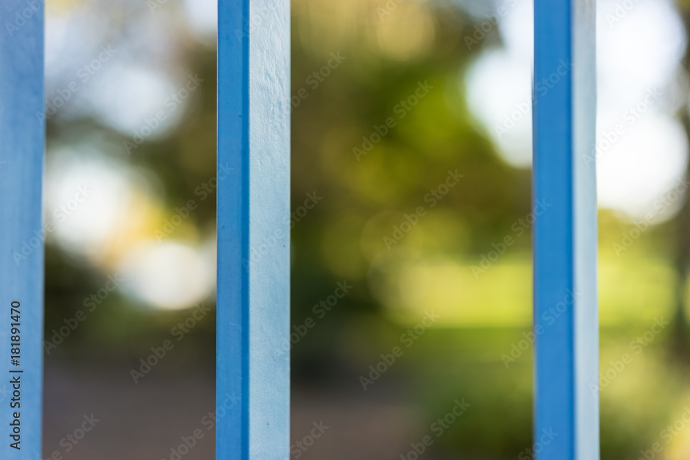 closed park seen through blue gate in summer closed park seen through blue gate in summer