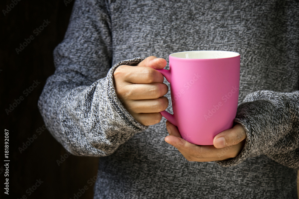 The girl in a cozy knitted sweater holding coffee cup The girl in a cozy knitted sweater holding coffee cup