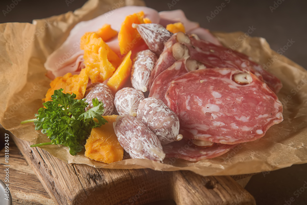 Meat and cheese sliced, sausage, bread. French traditional cuisine. Dark background.