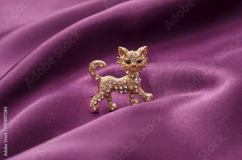 Brooch golden kitten with diamonds on silk fabric