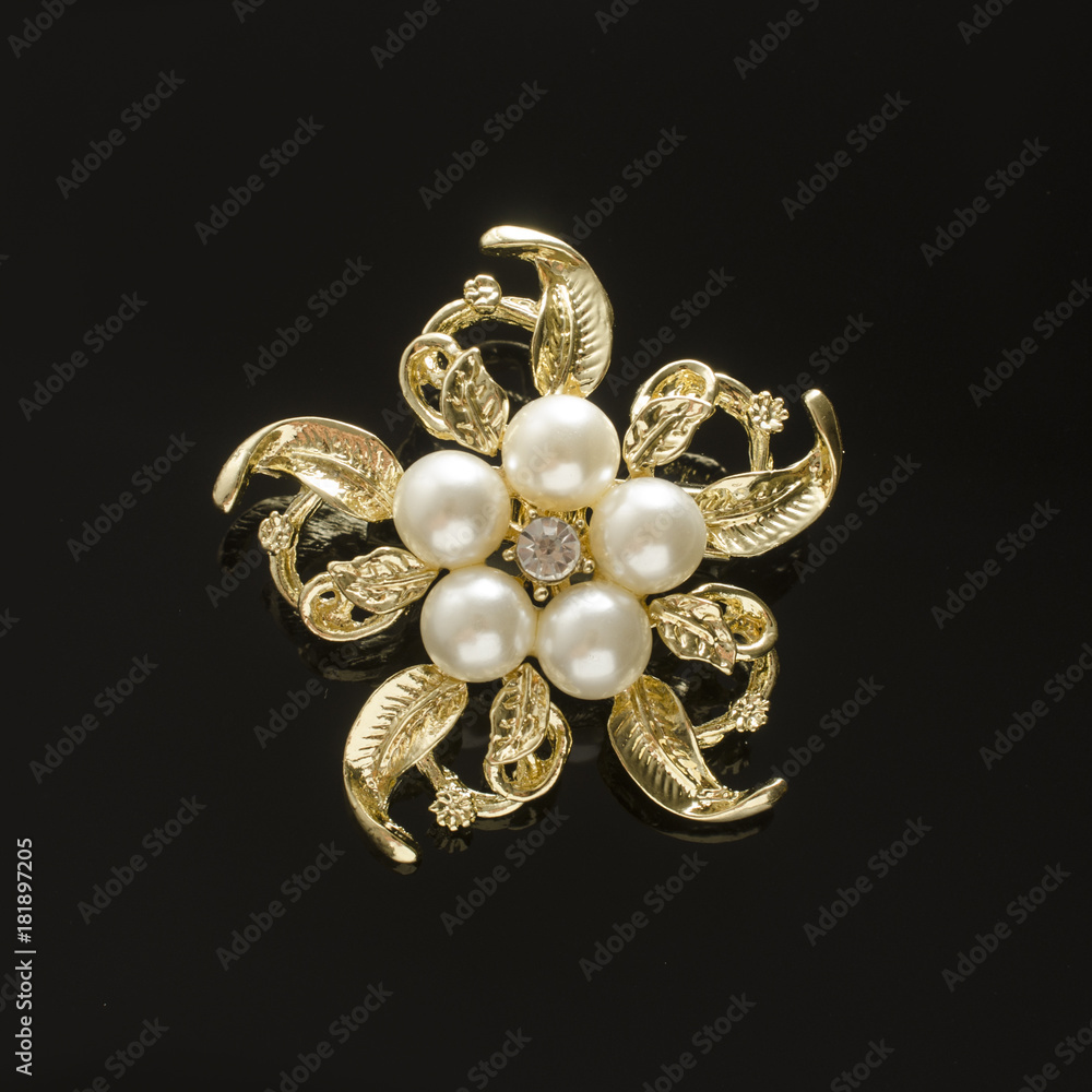 gold brooch flower with pearl isolated on black gold brooch flower with pearl isolated on black