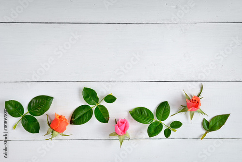 Flowers composition. Red roses on a white wooden background. Flat lay, top view.