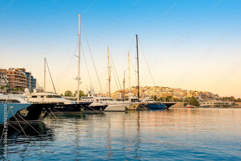 Sailing and luxury motor yachts in  marina of Zeas. Sunset and view of Kastela in the background. Piraeus city, Greece