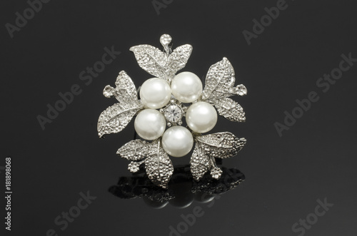 silver brooch flower with pearls isolated on black