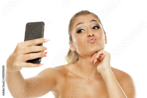 Young beautiful woman making selfies on white background photo