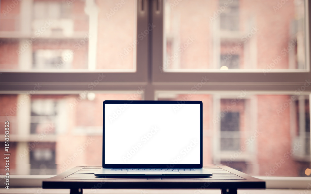 Laptop with blank screen on table in modern loft industrial interior Laptop with blank screen on table in modern loft industrial interior