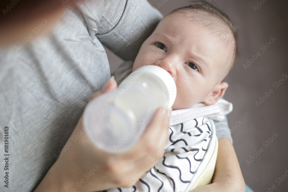 Mother holding and feeding newborn baby from bottle. Mother holding and feeding newborn baby from bottle.