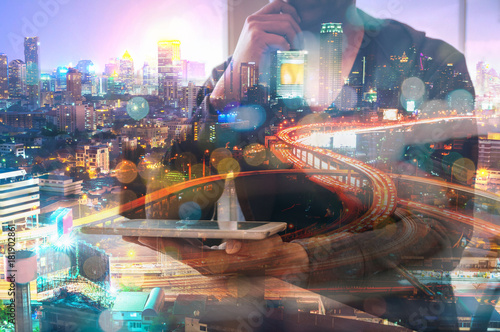 Double Exposure of Man or Male hold Digital Wireless Tablet with Glowing Modern City Scenic