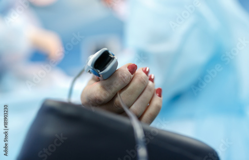 Patient's hand with a sensor in operating room