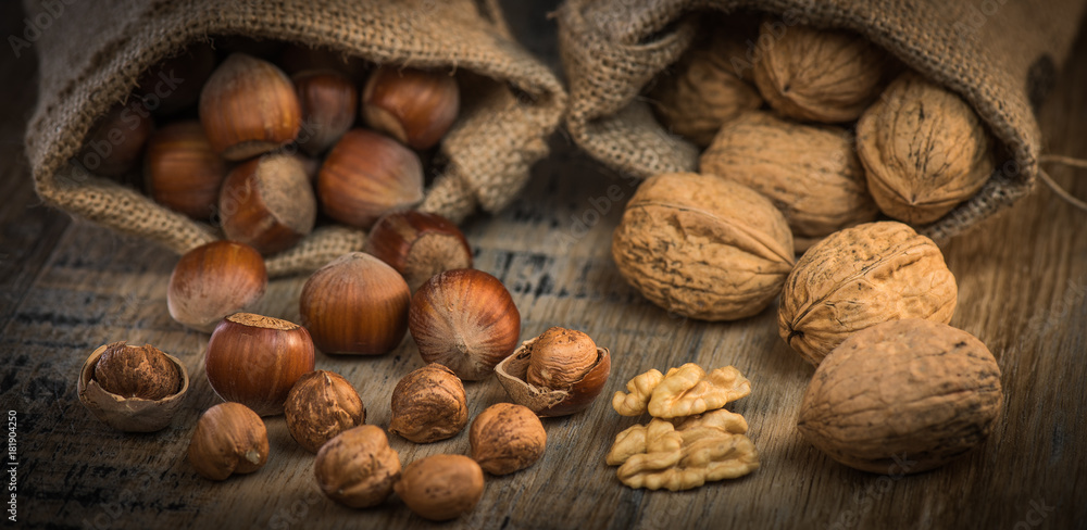 Walnuts and Hazelnut in jute bag on wooden background Walnuts and Hazelnut in jute bag on wooden background