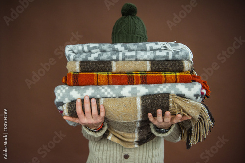 man holding pile of blankets photo
