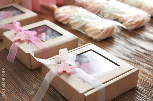 Boxes with baby shower favors on wooden table photo