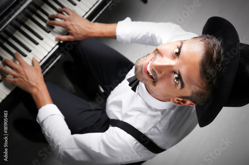 Young man playing piano, to...