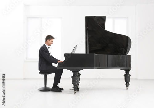 Fototapeta Young man playing piano indoors