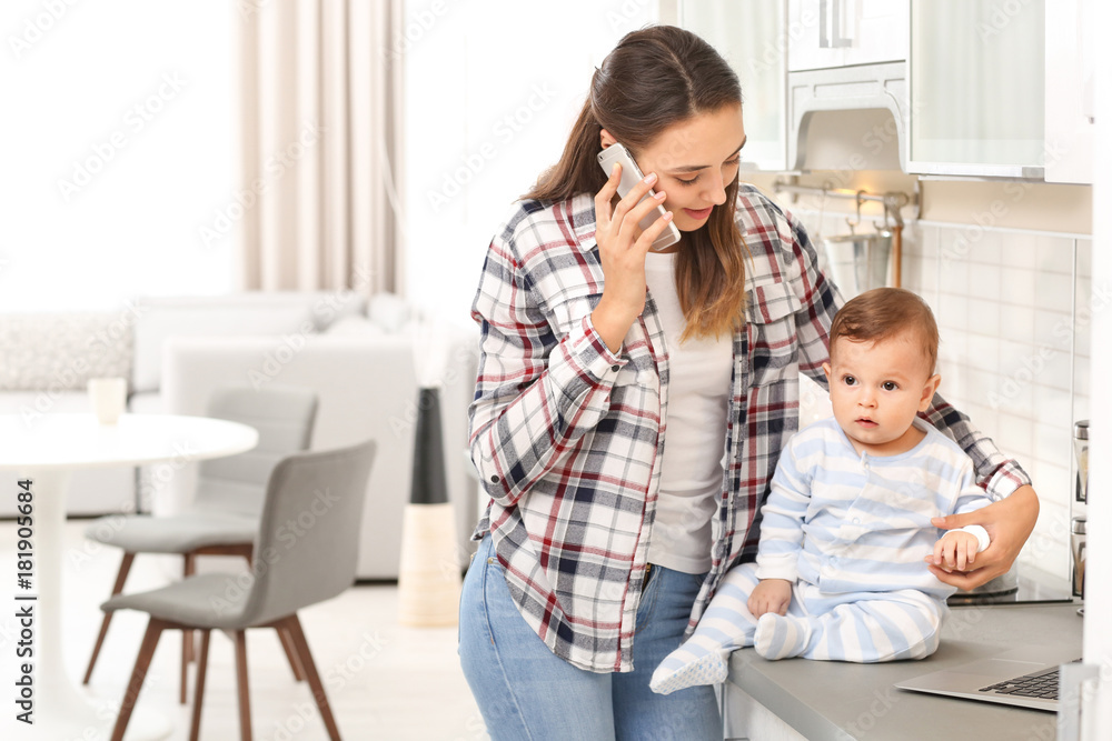 Young woman with baby working in home office Young woman with baby working in home office