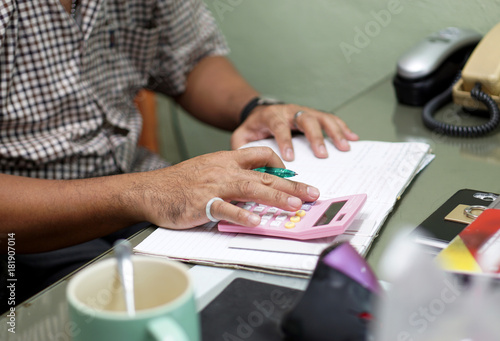 Closeup hand's man using pink calculator, business background and concept