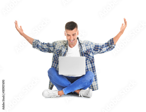 Happy young man with laptop...