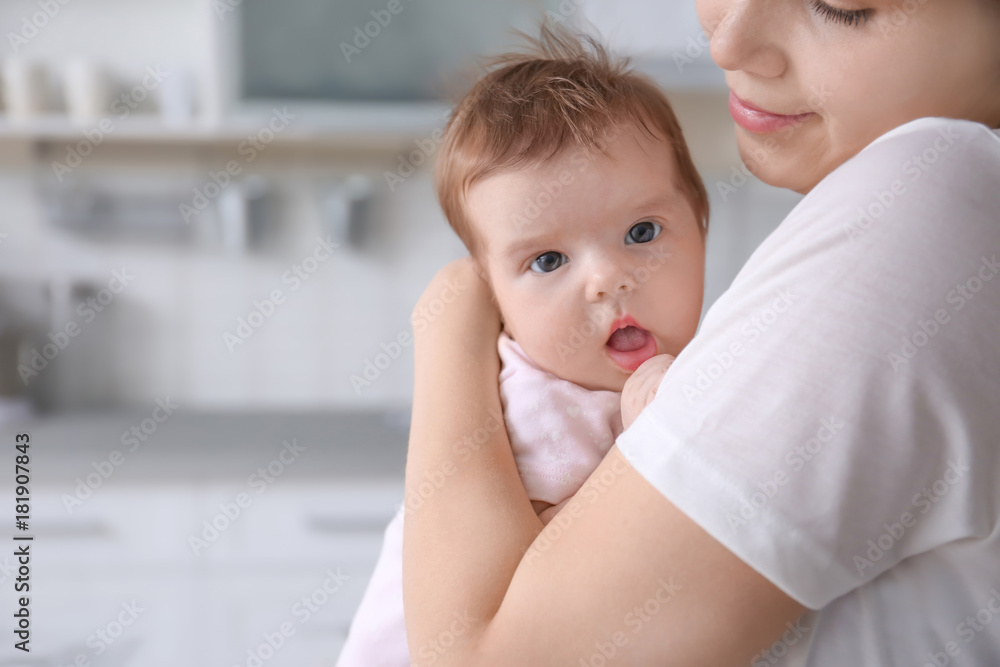 Young mother holding baby in kitchen Young mother holding baby in kitchen