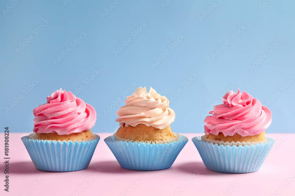 Yummy cupcakes on color background