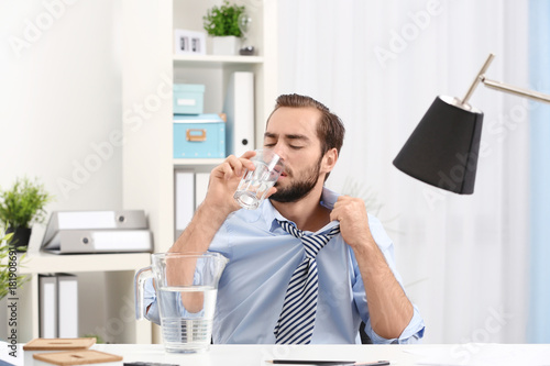 Young man drinking water in...