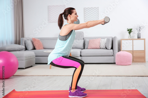 Young sporty woman doing exercise at home © Africa Studio