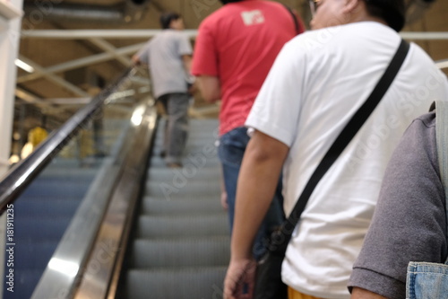 blur picture background of people is shopping and line up on escalator in furniture mall .