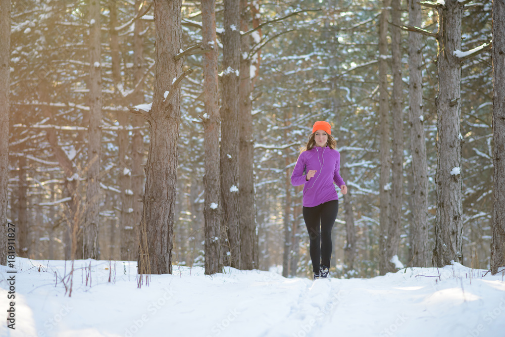 Young Woman Running in Beautiful Winter Forest at Sunny Frosty Day. Active Lifestyle Concept.