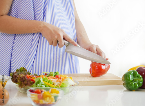 Pregnant woman preparing meal at table in the kitchen healthy nutrition during pregnancy