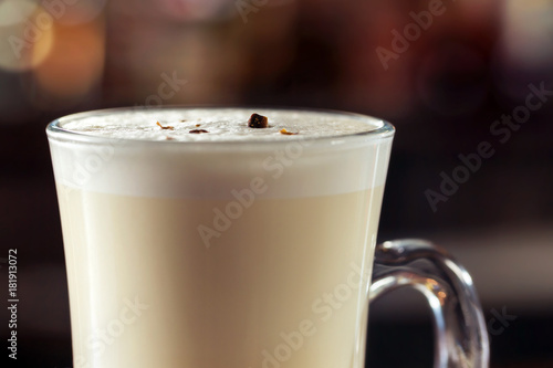 Closeup image of milk shake cocktail decorated with chocolate at blurred bright background.