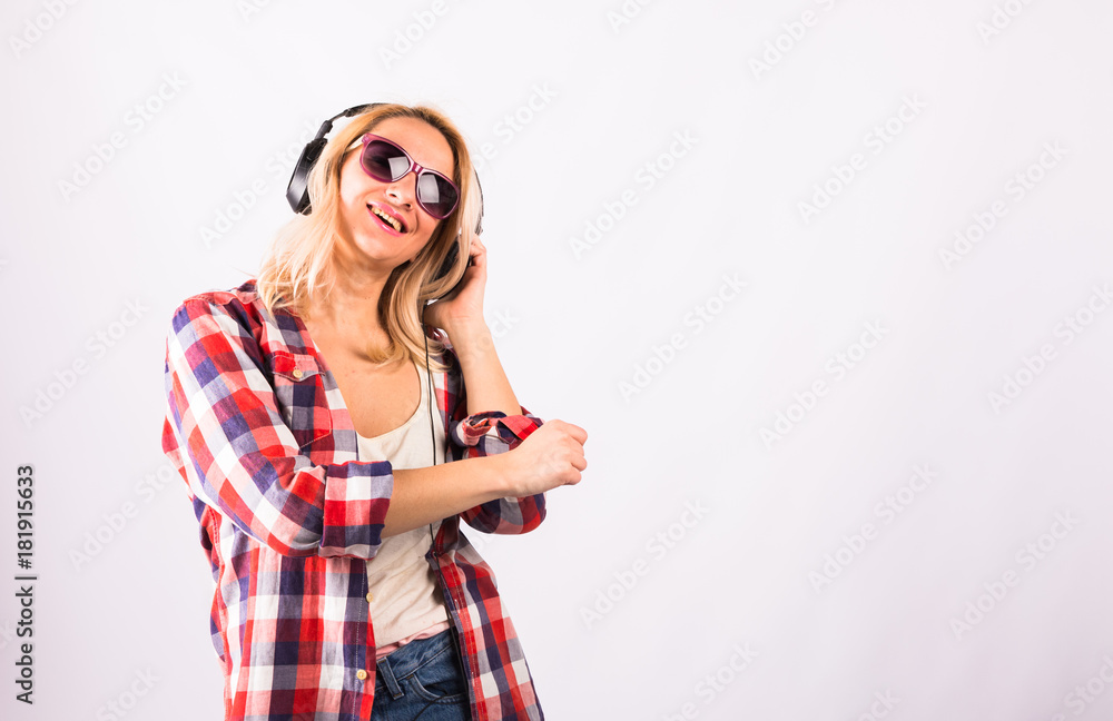 Fototapeta premium Happy pretty woman having fun with headphones against white background.