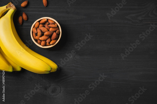 Selection of healthy food for heart. Bananas and almond on black gooden photo