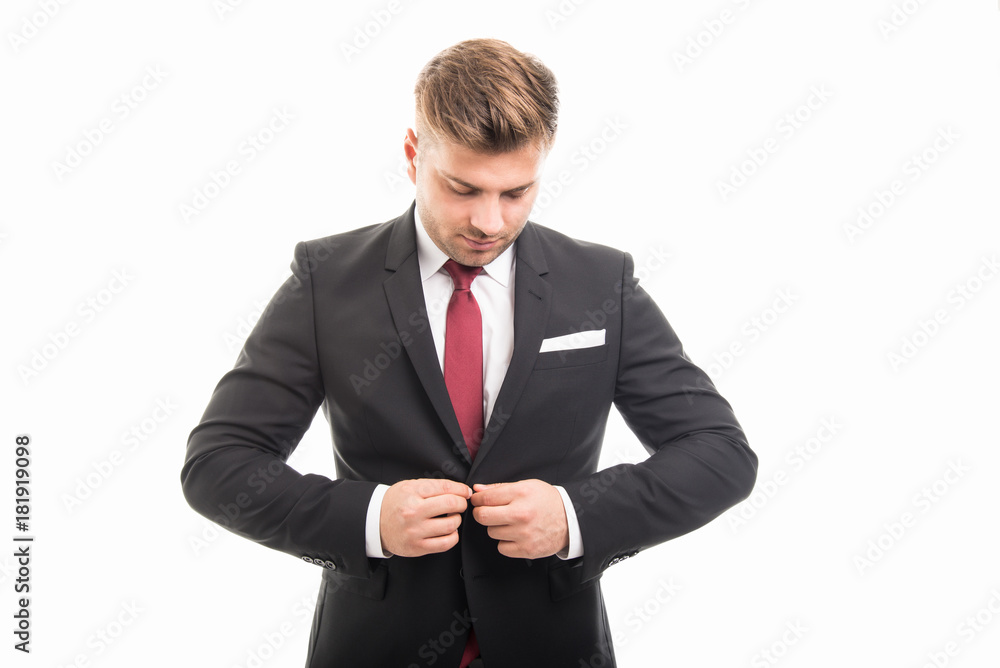 Handsome business man standing buttoning his jacket Handsome business man standing buttoning his jacket