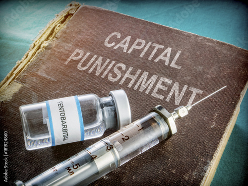  Vial And Vintage Syringe With Medicine On An Old Book Of Capital Punishment, Conceptual  photo
