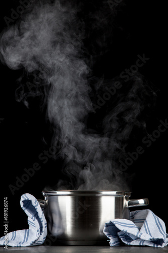 Steaming pot on black background