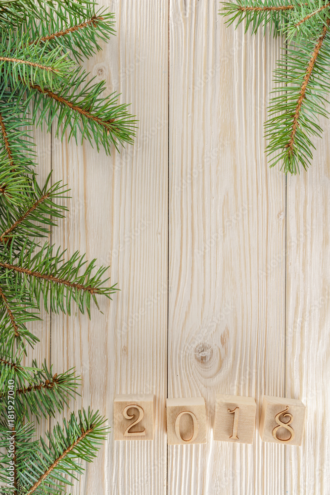 Christmas cubes on wooden background. New year mood. Spruce branches on the left. The frame of spruce. Christmas cubes on wooden background. New year mood. Spruce branches on the left. The frame of spruce.