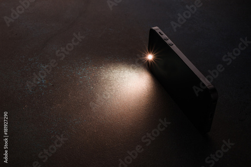 Lantern smartphone shines on a dark background.