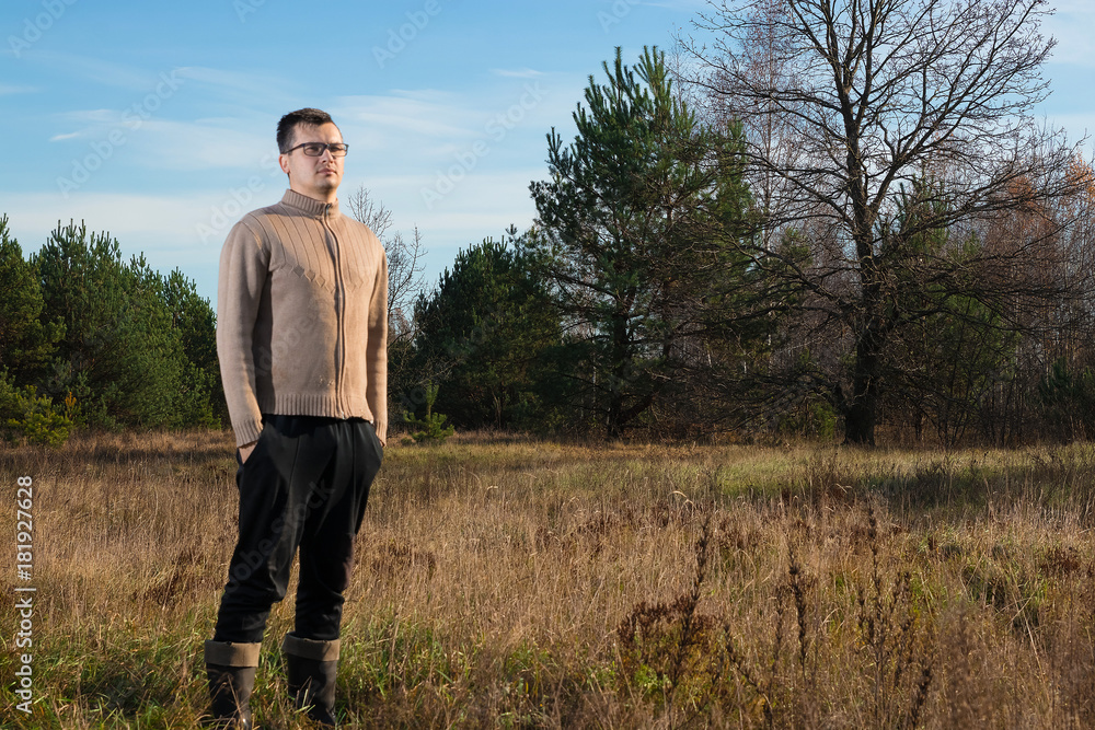 A man in rubber boots is standing in nature. The concept of outdoor recreation. A man in rubber boots is standing in nature. The concept of outdoor recreation.
