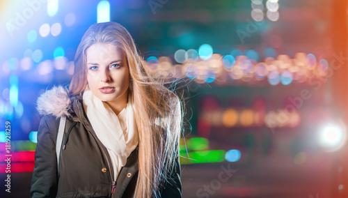 Night portrait of young girl in colorful city lights