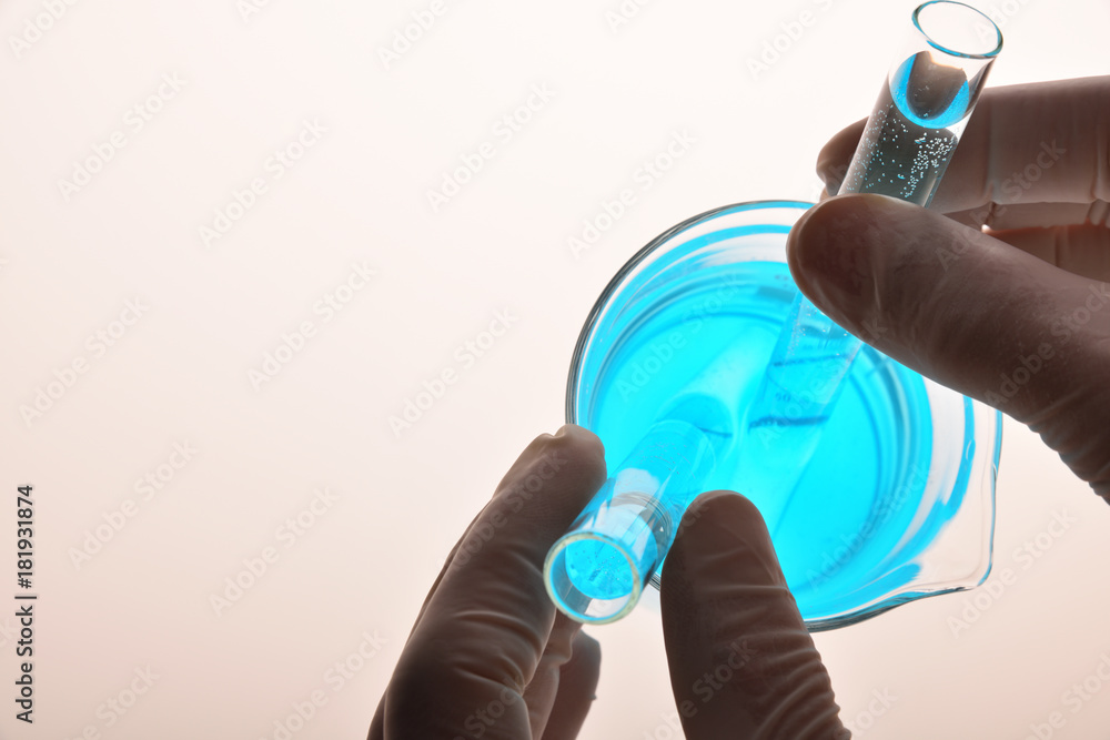 Hands of laboratory worker with test tubes and beaker Hands of laboratory worker with test tubes and beaker