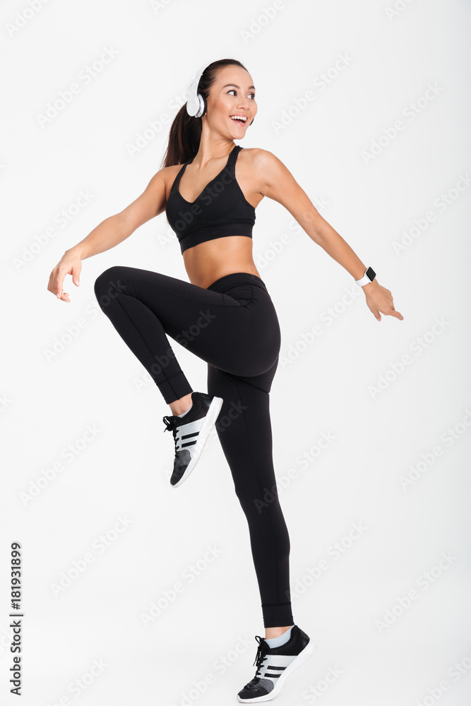 Full length portrait of a cheerful asian fitness woman