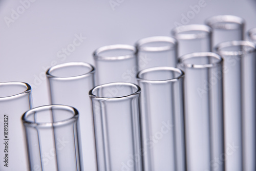 Row of empty test tubes gray background