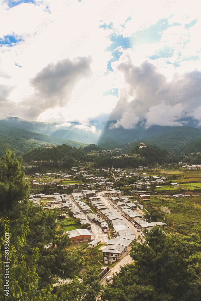 Sunrays leaking from  clouds over peaceful village in Bumthang valley, Bhutan.