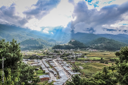 Sunrays leaking from  clouds over peaceful village in Bumthang valley, Bhutan.
